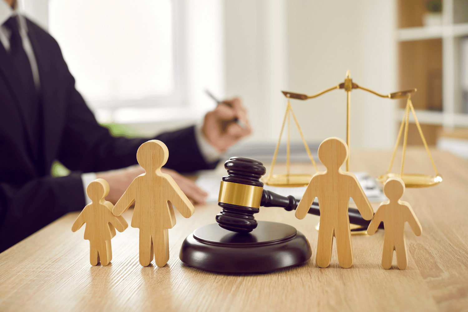 wooden figures representing coparents and children with a judge's gavel for Custody Blueprint Affiliate Program